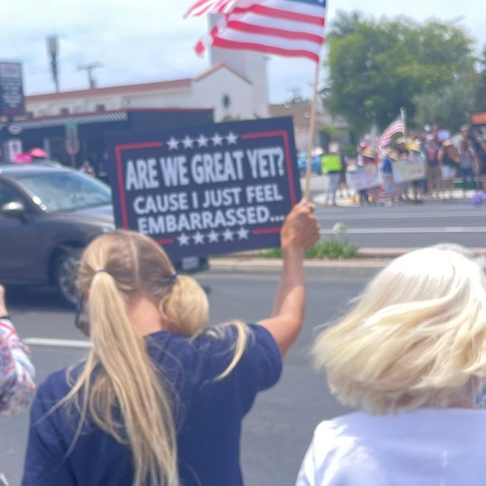 Img: flag, person, american flag, adult, female, woman, city, street, car, t-shirt