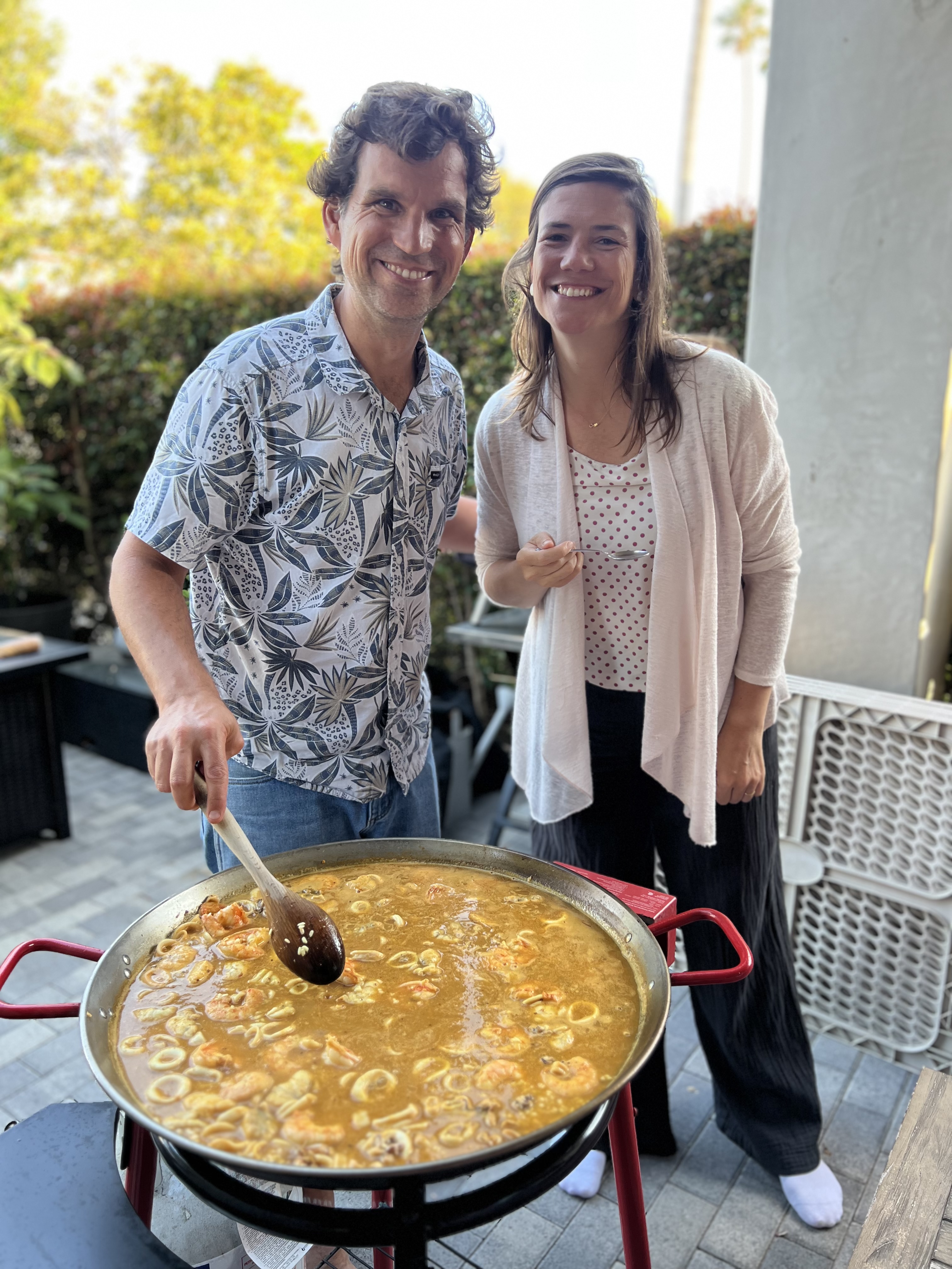 Img: food, stirring food, adult, female, person, woman, male, man, spoon, necklace