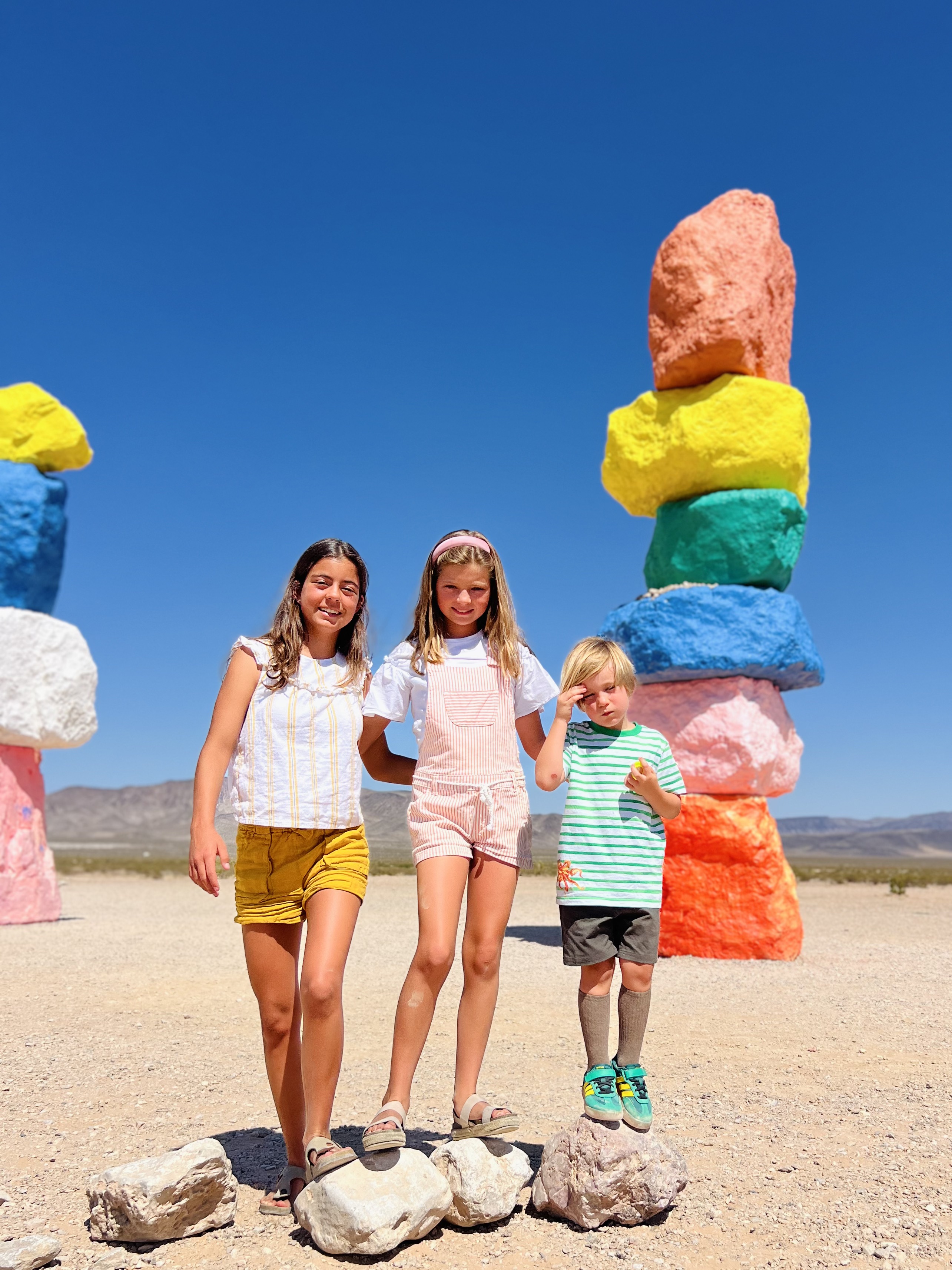 Img: shorts, rock, person, female, girl, teen, sandal, shoe, beachwear, outdoors