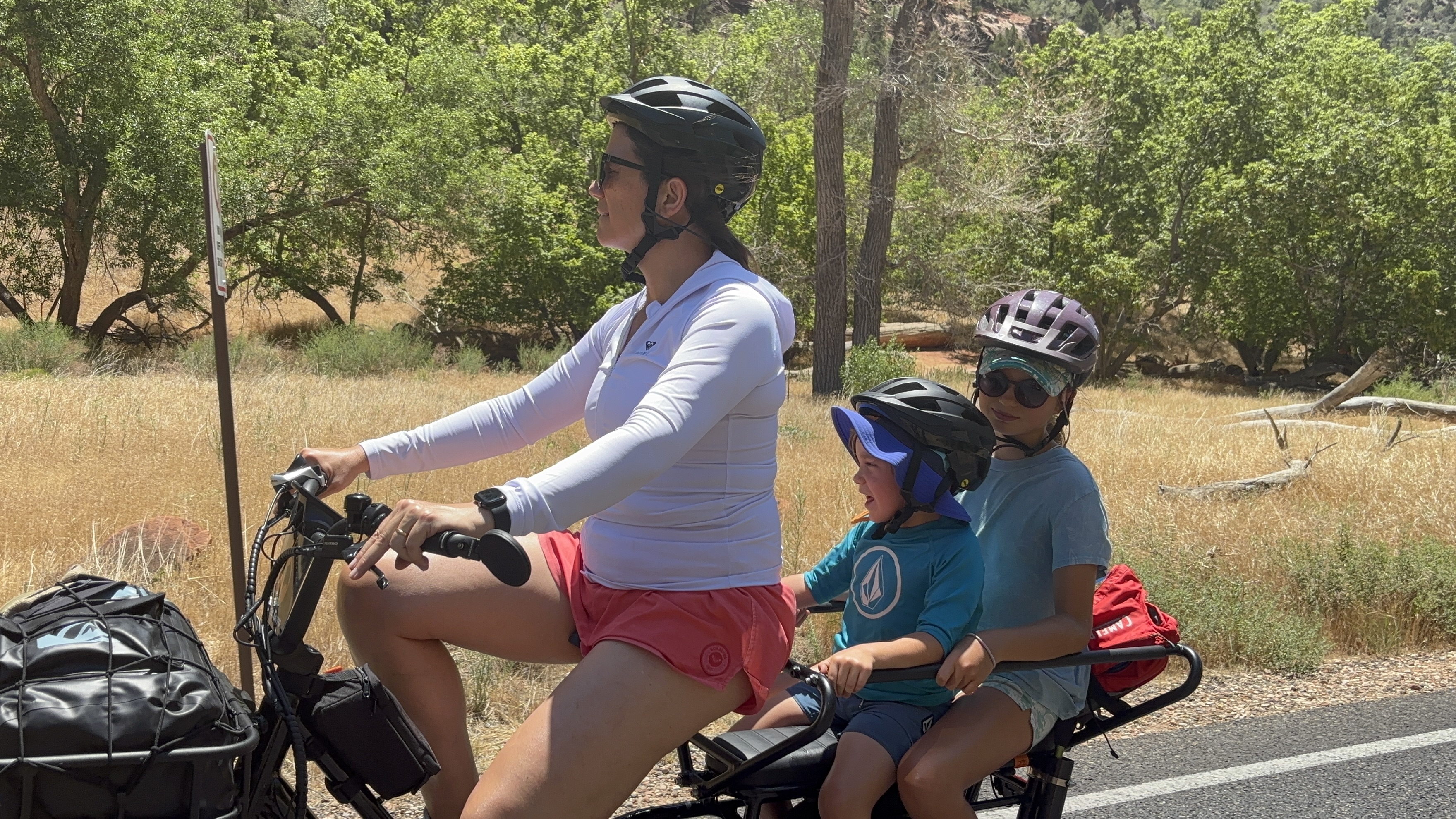 Img: helmet, adult, female, person, woman, handbag, wristwatch, vegetation, glasses, shorts