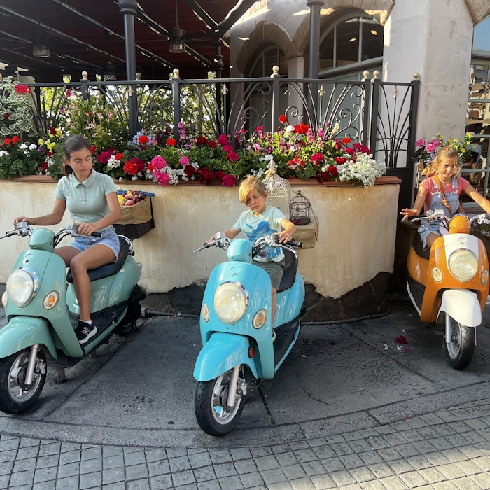 Img: moped, motor scooter, motorcycle, potted plant, person, shoe, scooter, child, female, girl