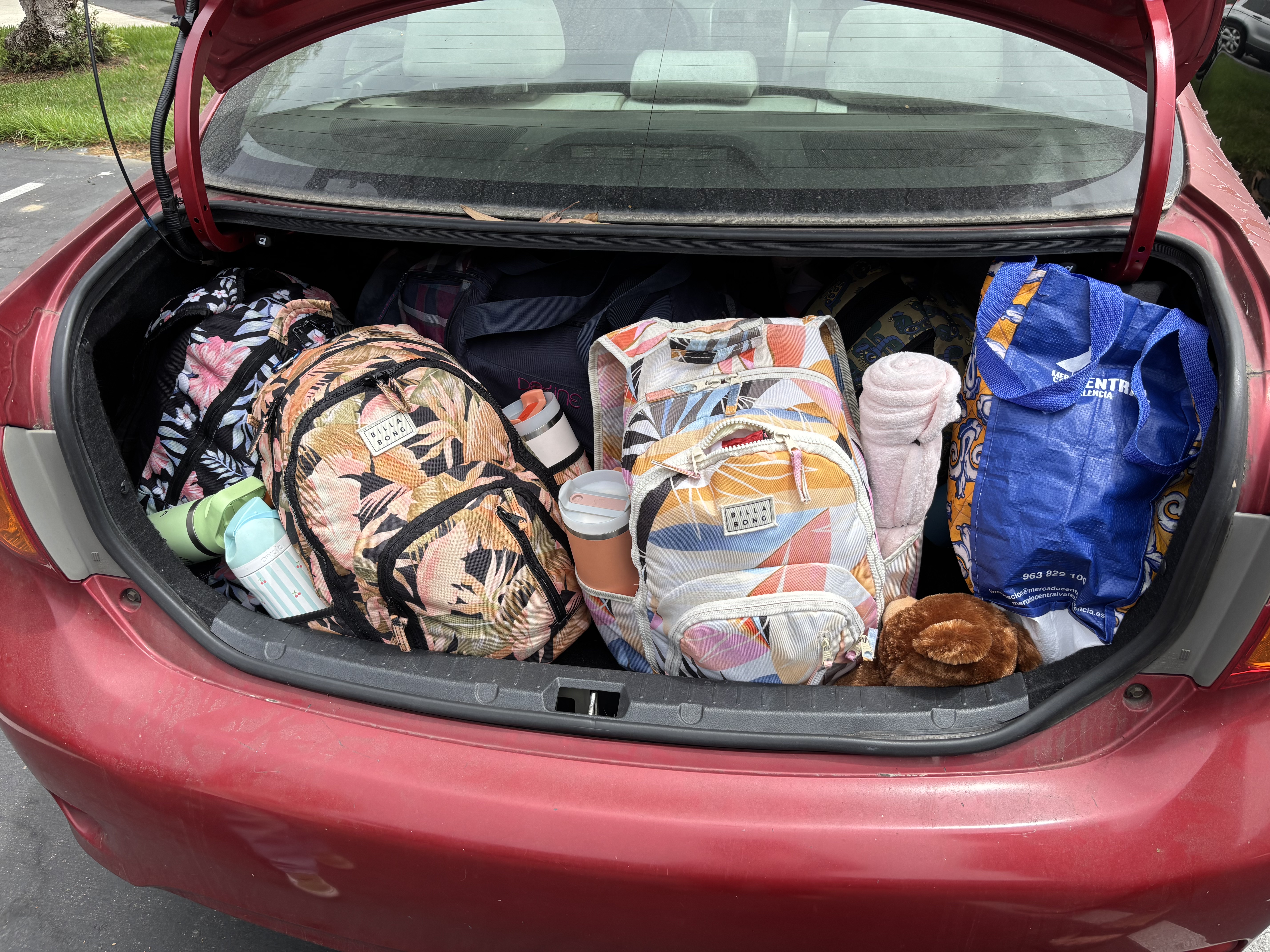 Img: car, transportation, vehicle, car trunk, bag, handbag, glove, toy, person, baby