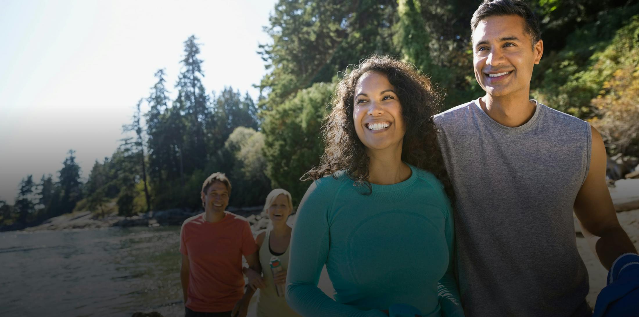 two couples looking at something off camera next to a body of water