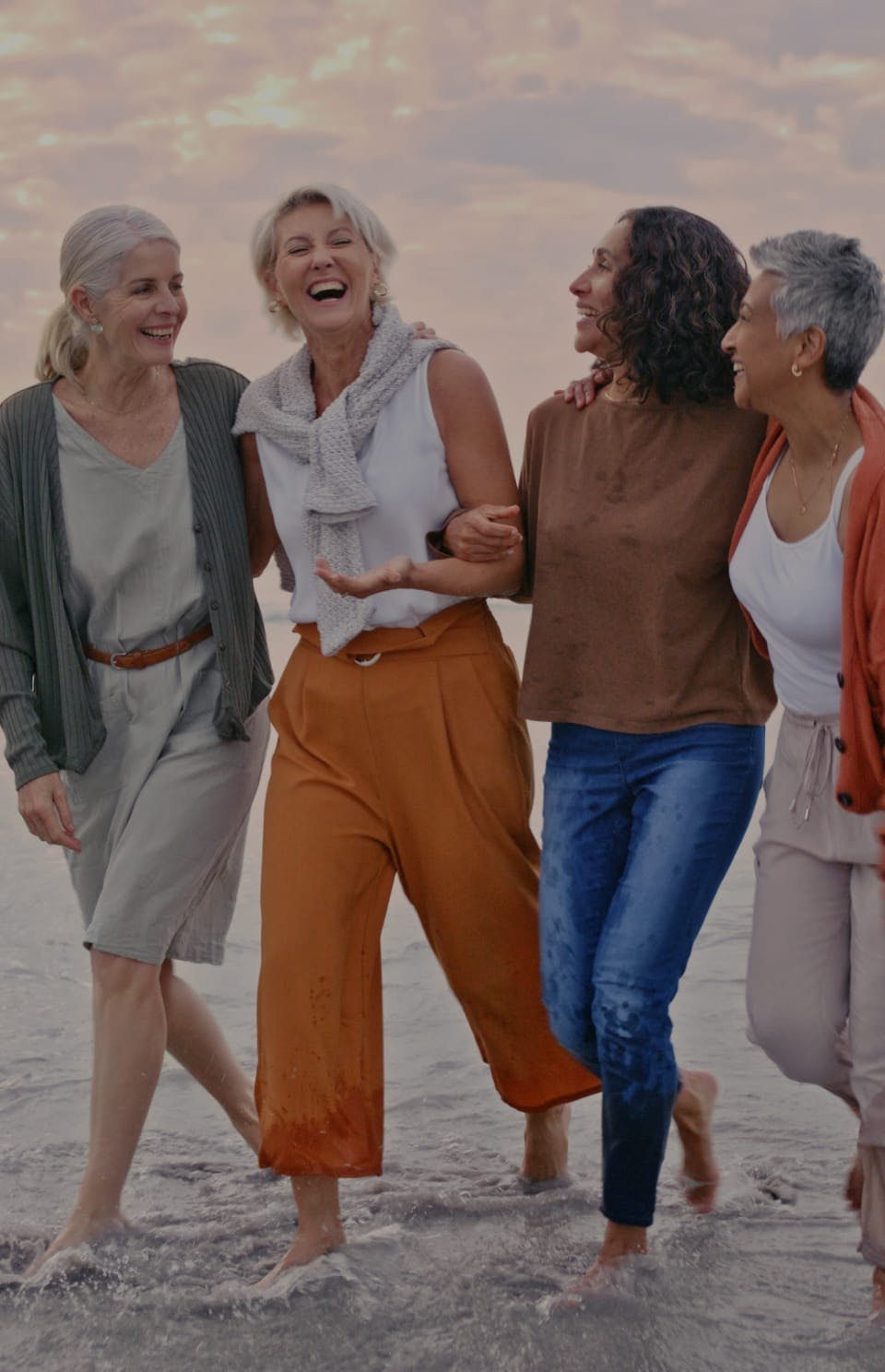 older women walking in water smiling