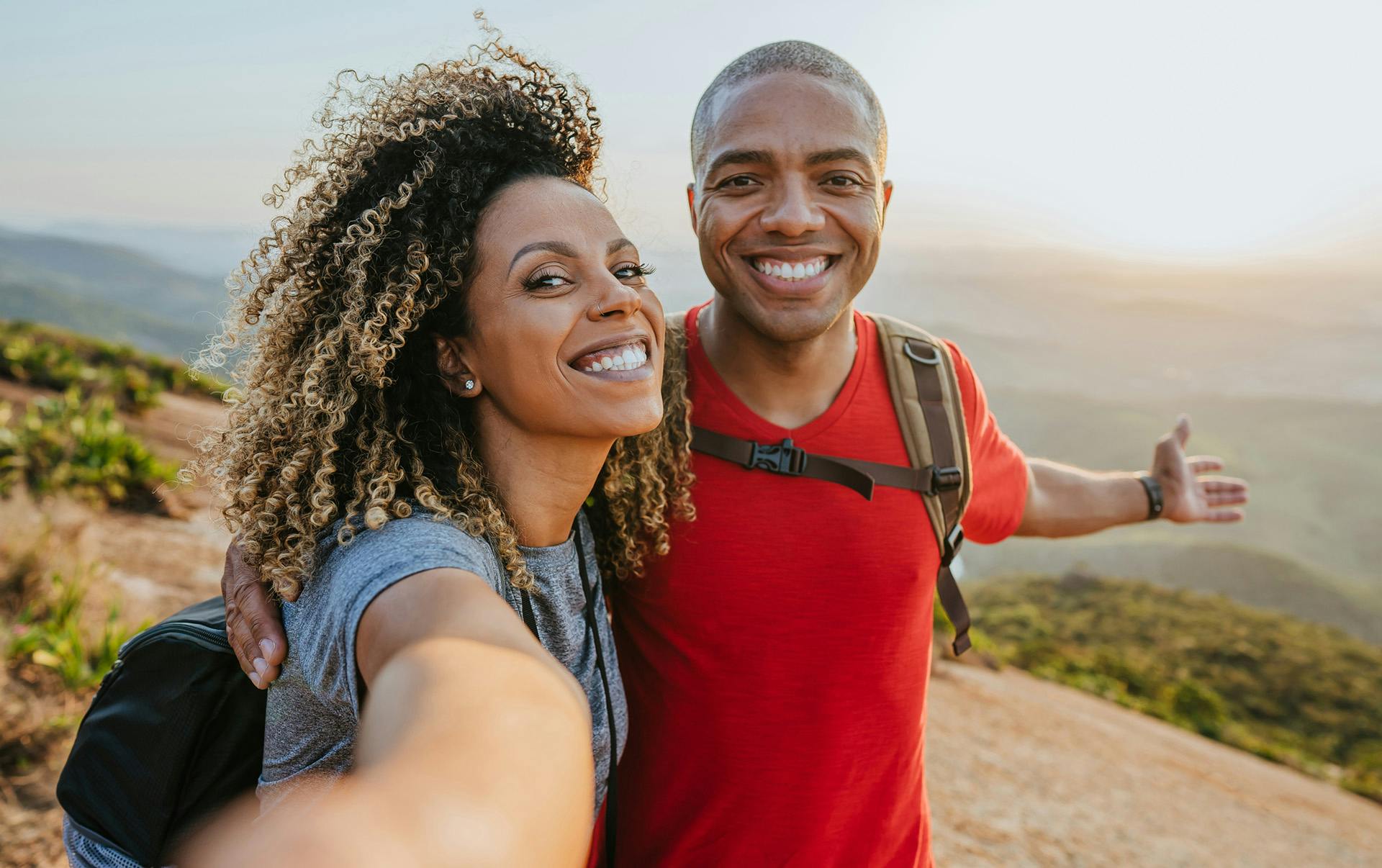 Couple taking selfie on hilltop.