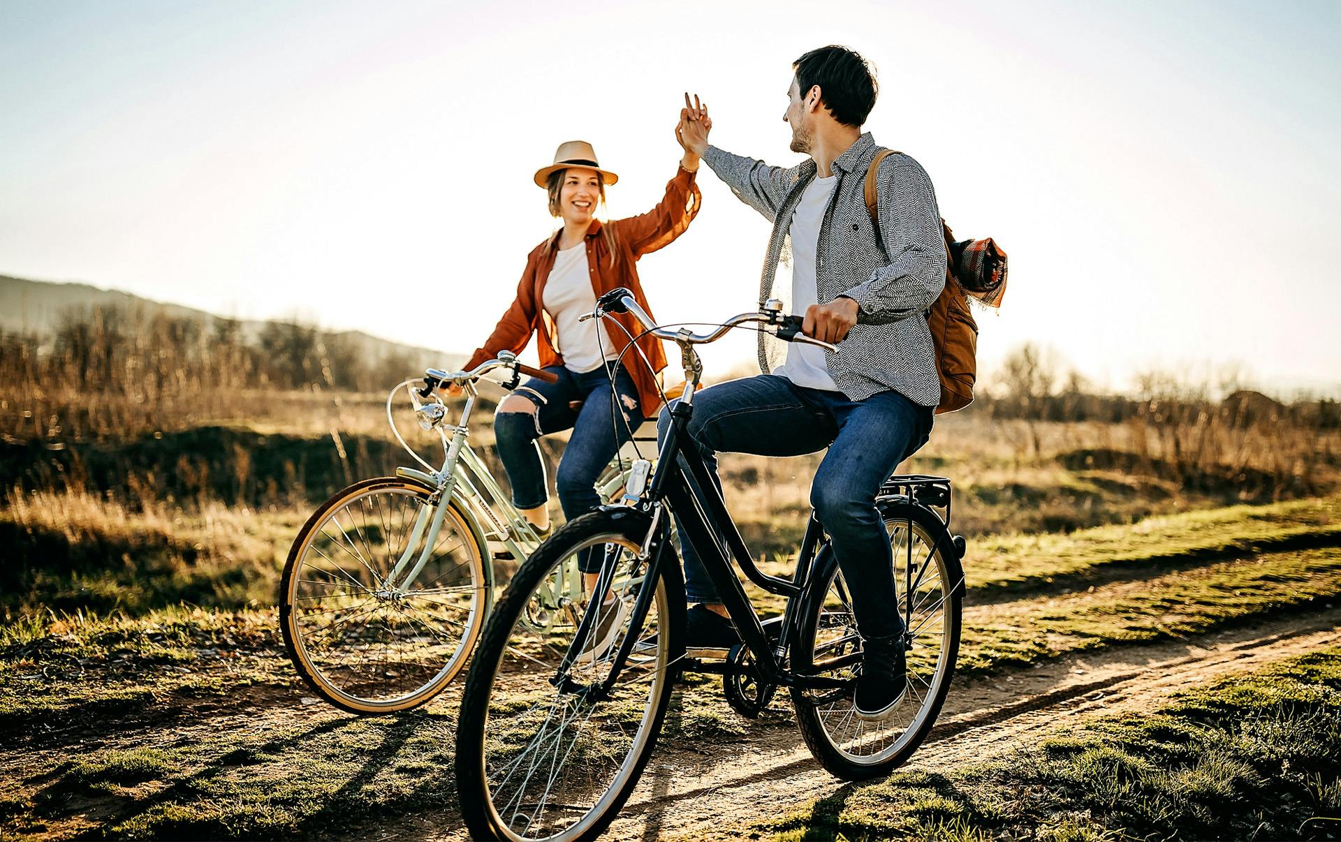 Couple holding hands while riding bikes.