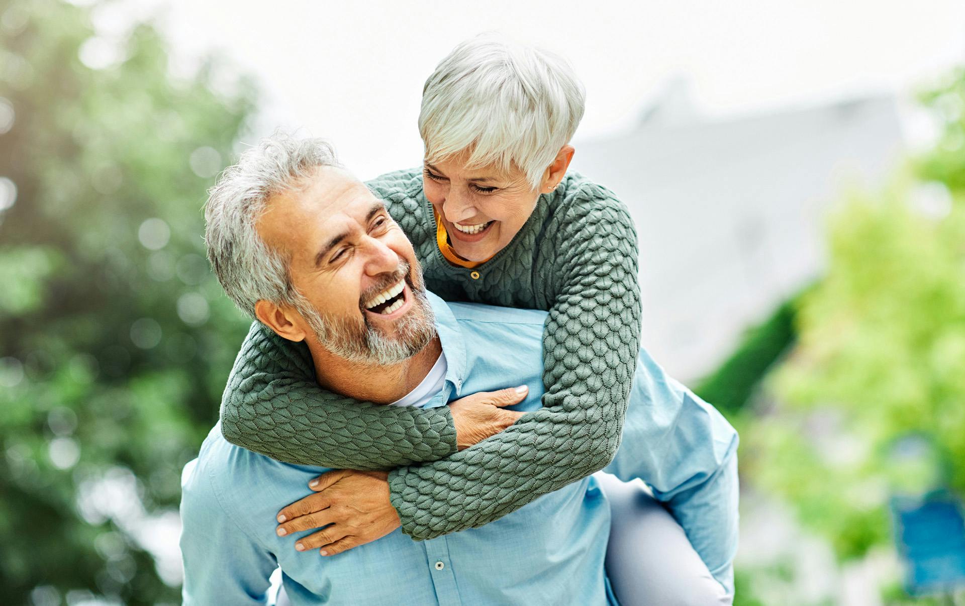 Man playfully carrying woman on his back.