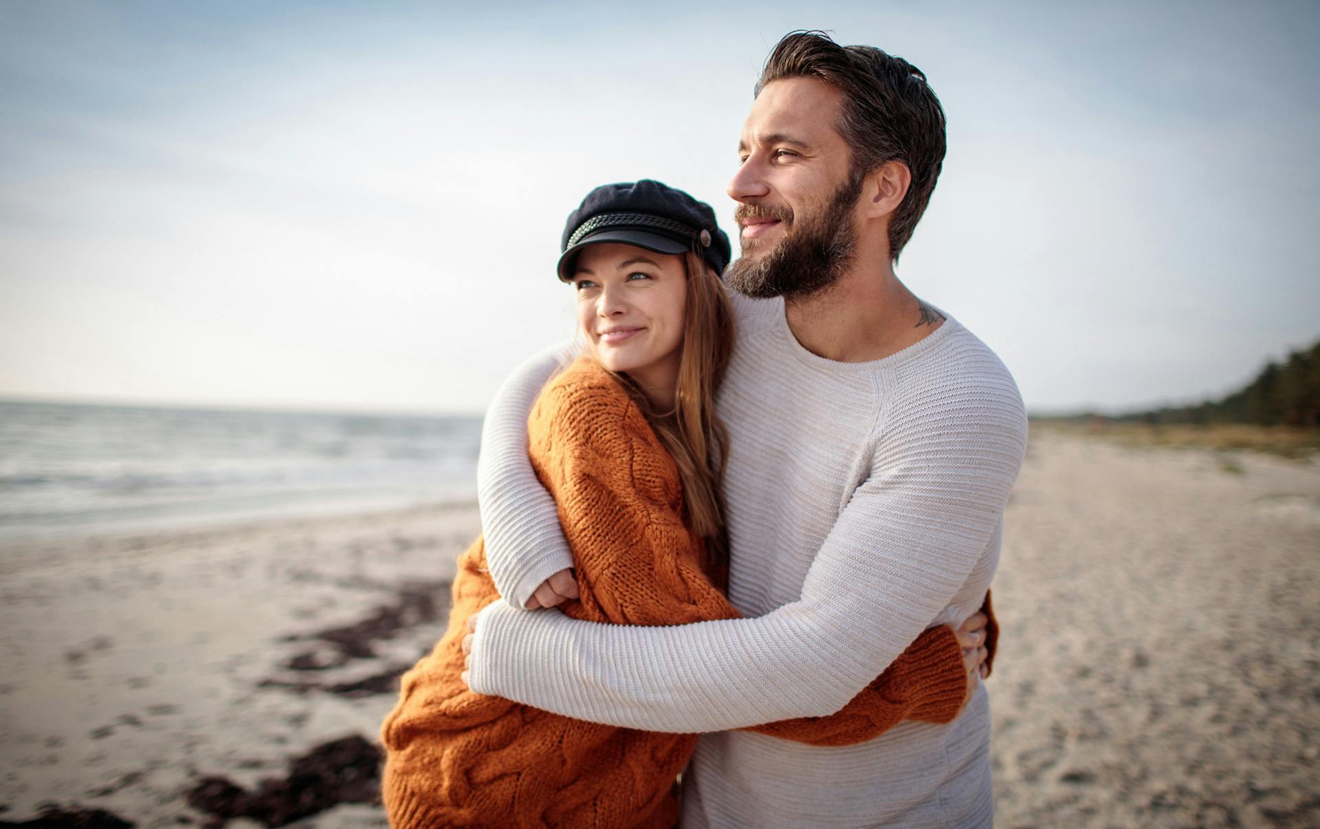 Couple hugging on beach.