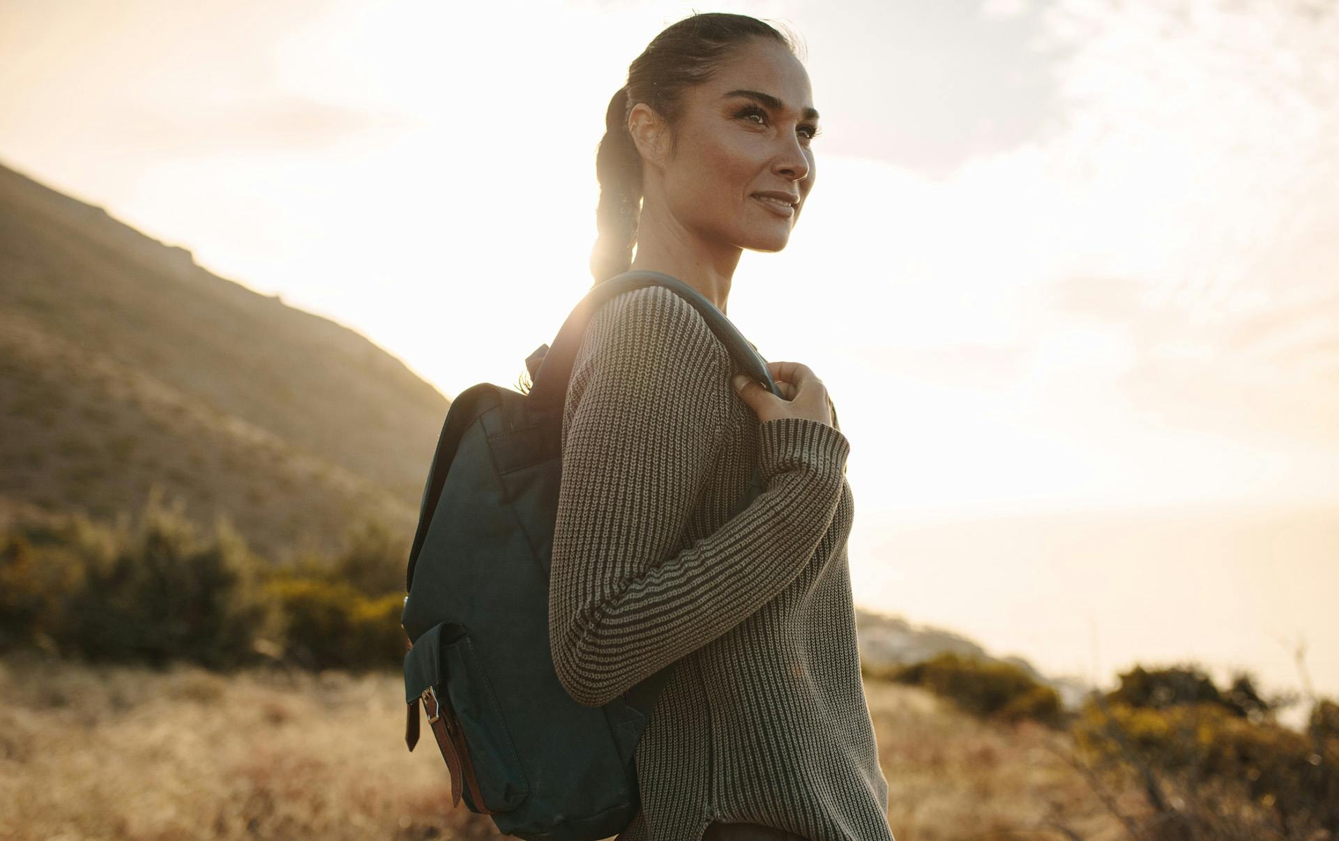 Woman wearing backpack outdoors.