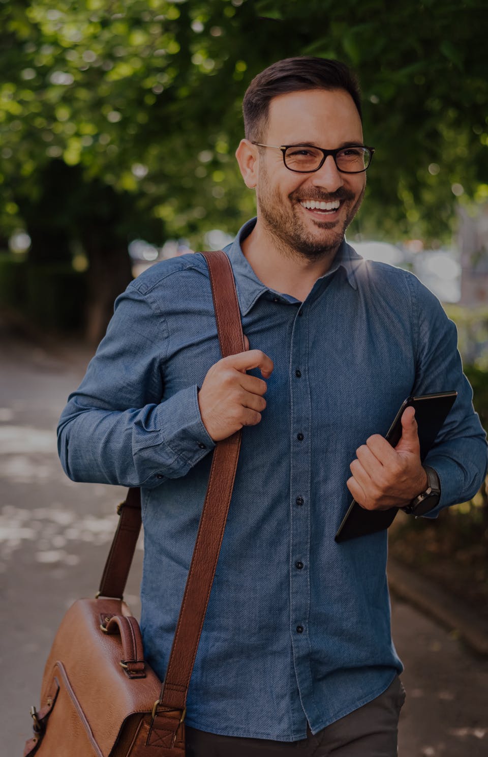 man smiling while holding a tablet