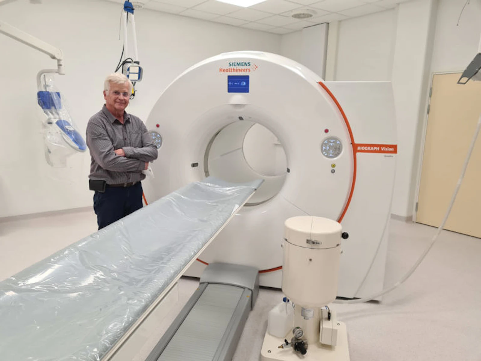 Radiochemist Hannu Sipilä next to a PET scan device