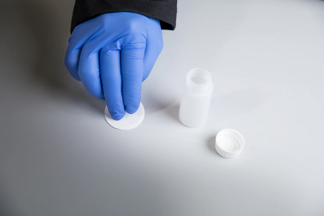 Individual performing a wipe test on a laboratory surface.