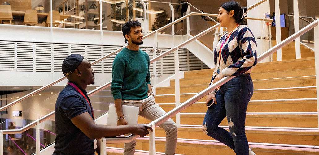 Three graduates talking at Sky's offices.