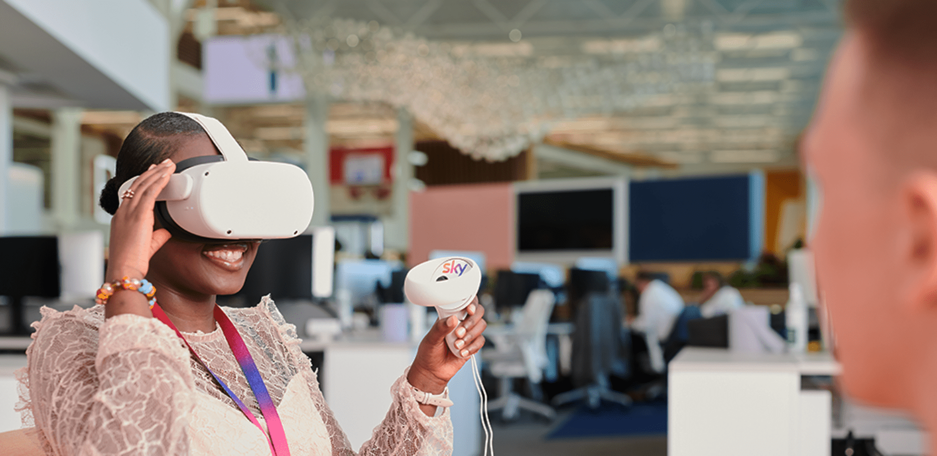 Girl sitting down at Sky with virtual reality headset on.