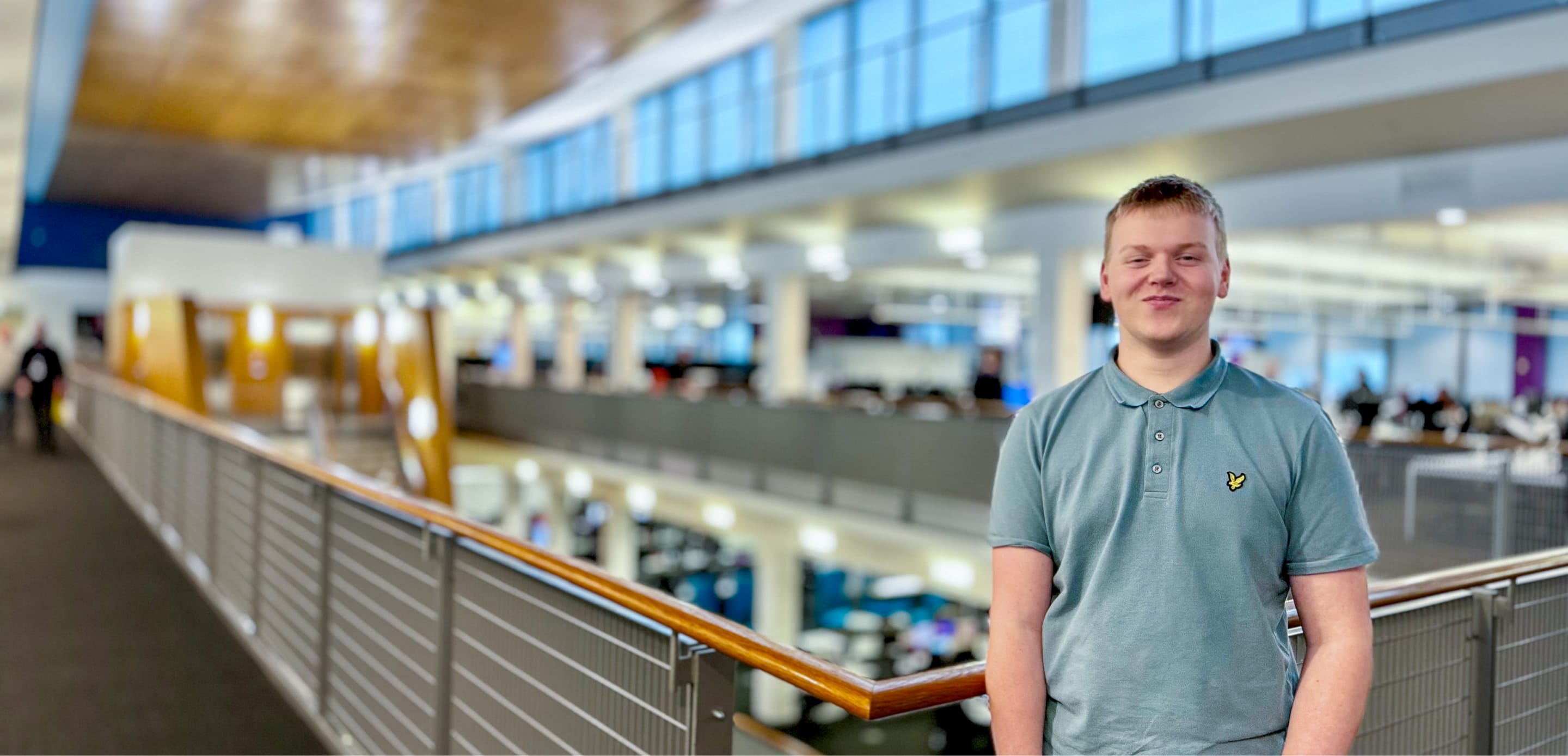 Man in a blue t-shirt stood in an office