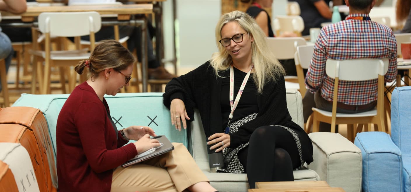 Two women talking together on couches