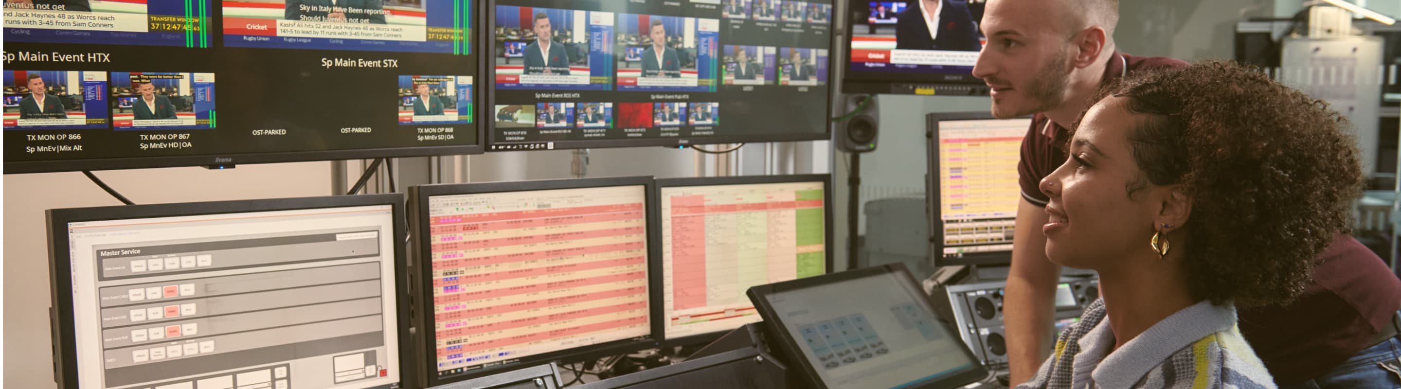 man and woman looking at multiple screens
