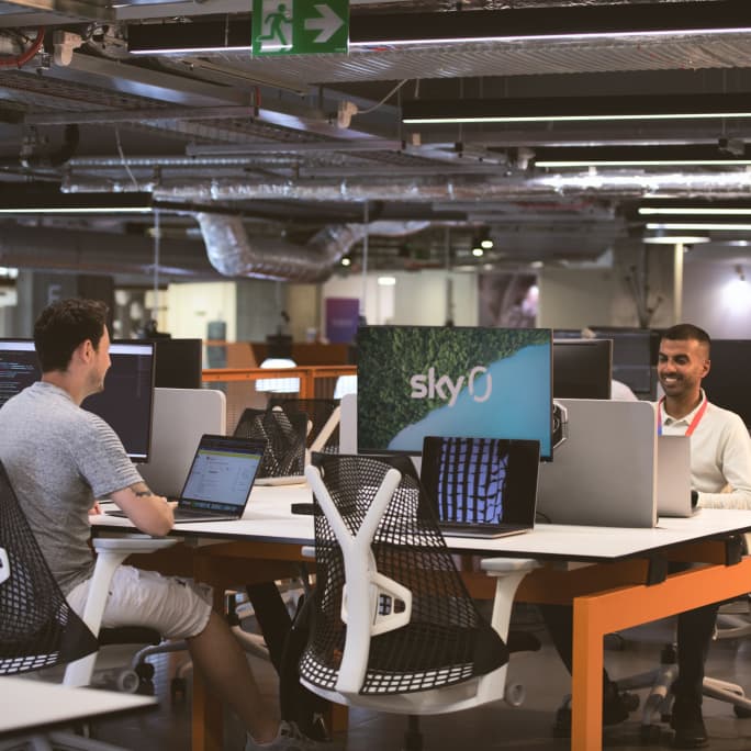 two people working from their laptops sitting opposite each other