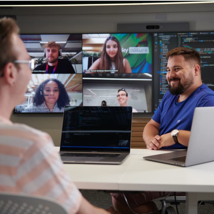 man smiling sitting opposite a colleague