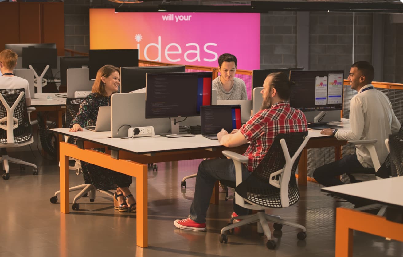People working on screens at a desk