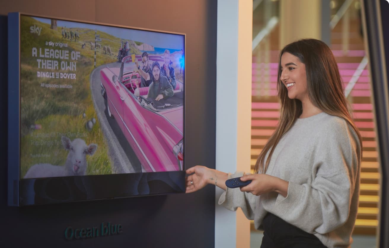 woman holding a remote, smiling in front a screen