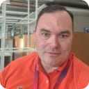 Image of a man wearing an orange t-shirt in an office