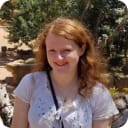 Image of girl with red hair wearing a white shirt outside