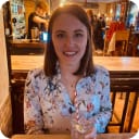 Image of women in a bar wearing a flower shirt, holding a drink