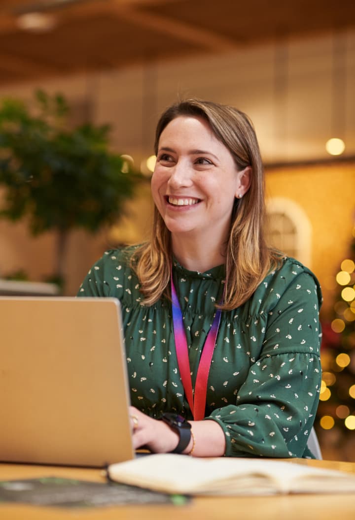 woman smiling up from her laptop screen