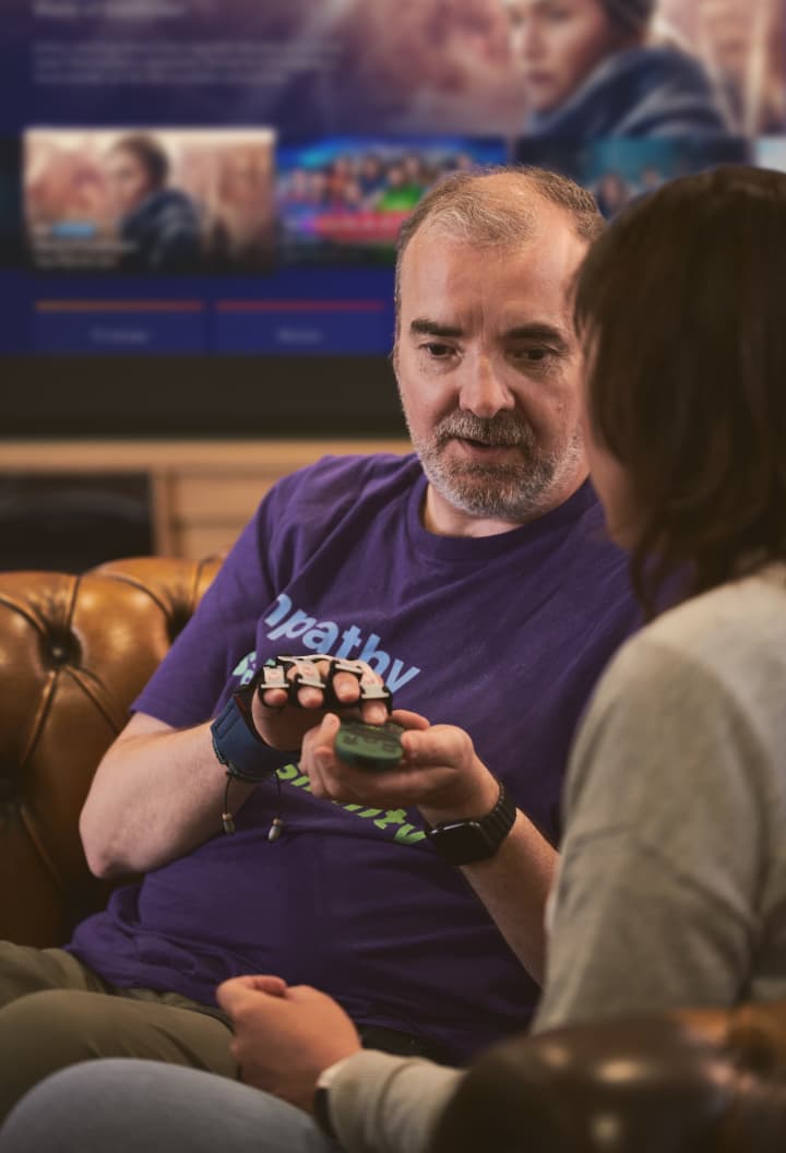 man sitting on couch talking to a person