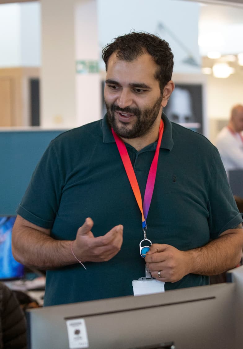 a man in a green polo and wearing the Sky lanyard