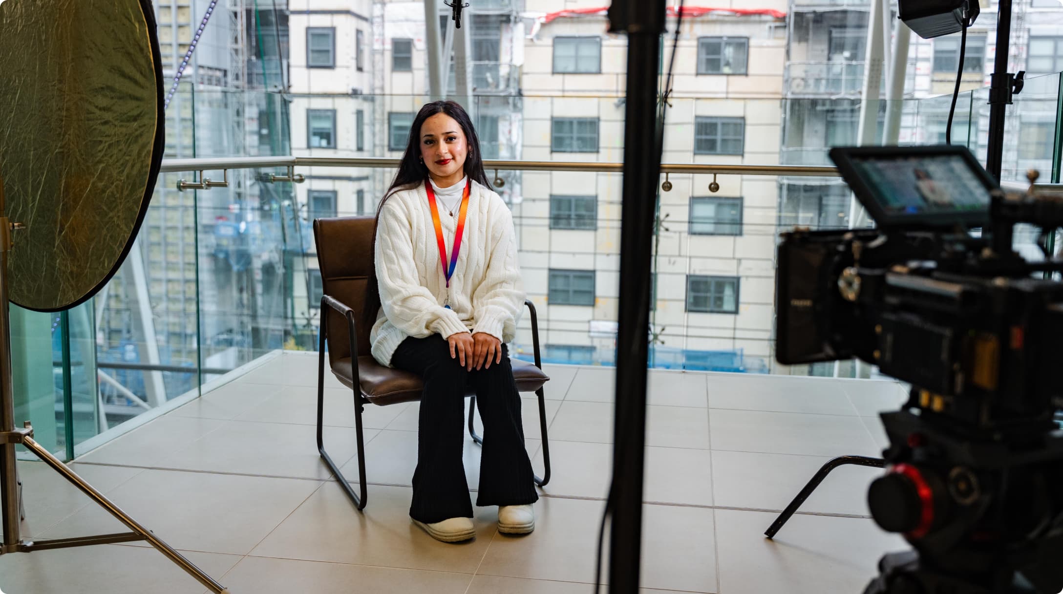 woman sitting in a chair in front of a recording camera