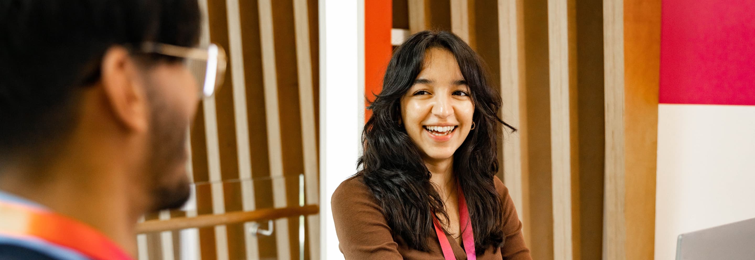 girl with black hair smiling at colleague