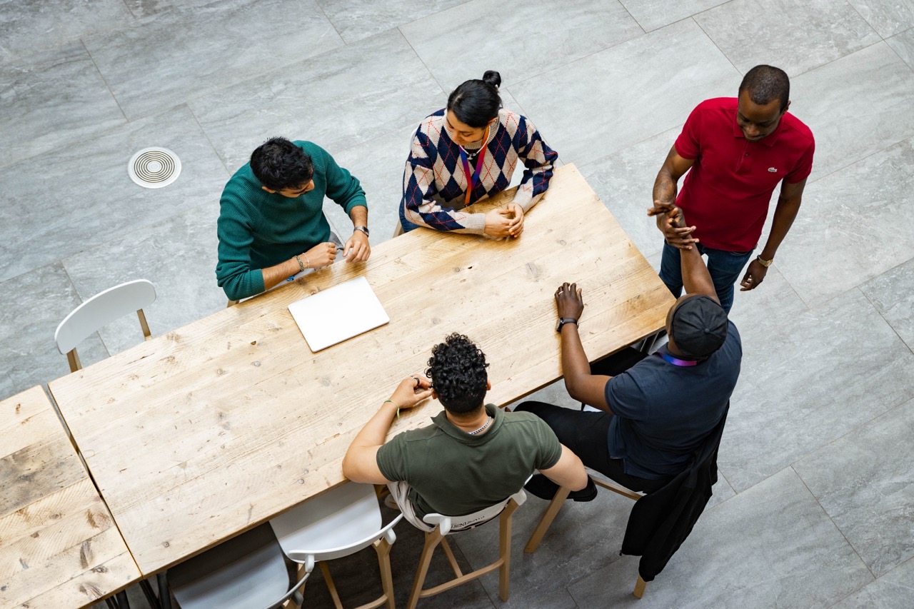 5 people at a table having a meeting