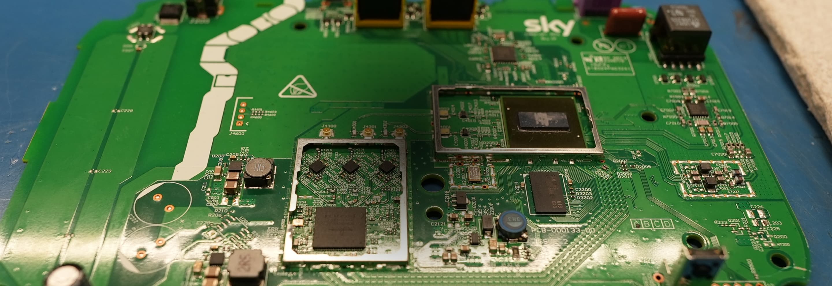 Close-up of green Sky circuit board with visible components, chips, and circuitry on a work surface.