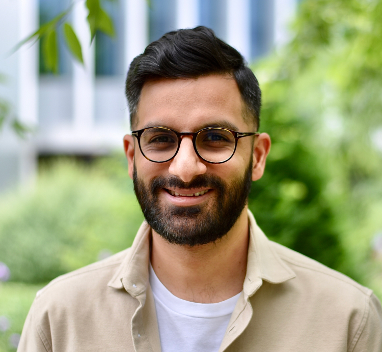 portrait shot of south asian man with a short beard and wearing glasses