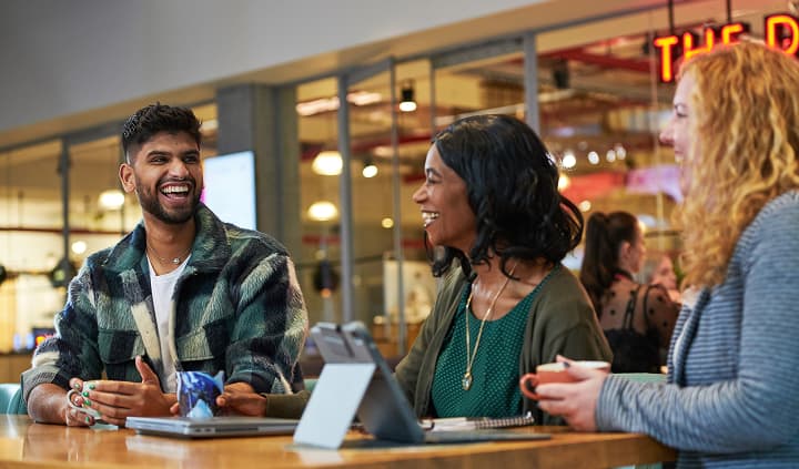 Man laughing with 2 women
