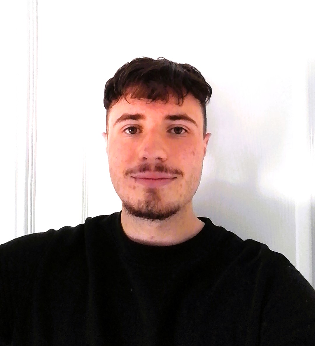Charlie, wearing a black top, looking into the camera against a white background