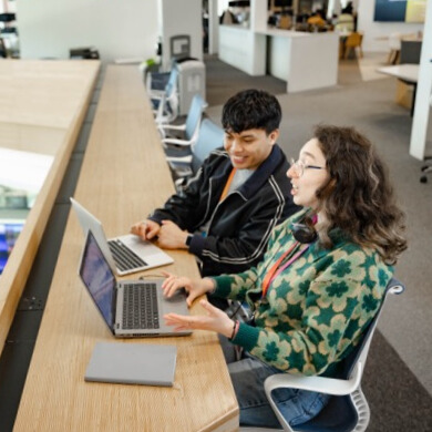 two people sitting and working on their laptops