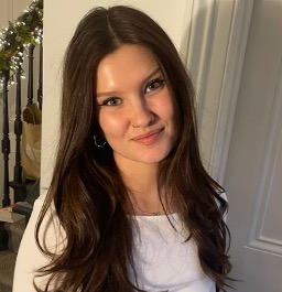 Isabella, a young woman with long dark brown hair, stood in front of a white background