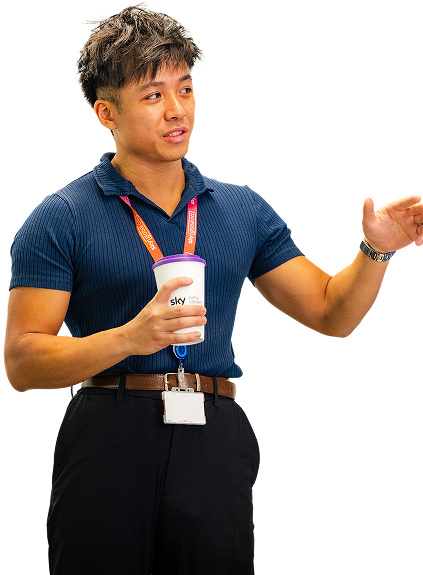 A man speaking whilst holding a cup with the Sky logo on