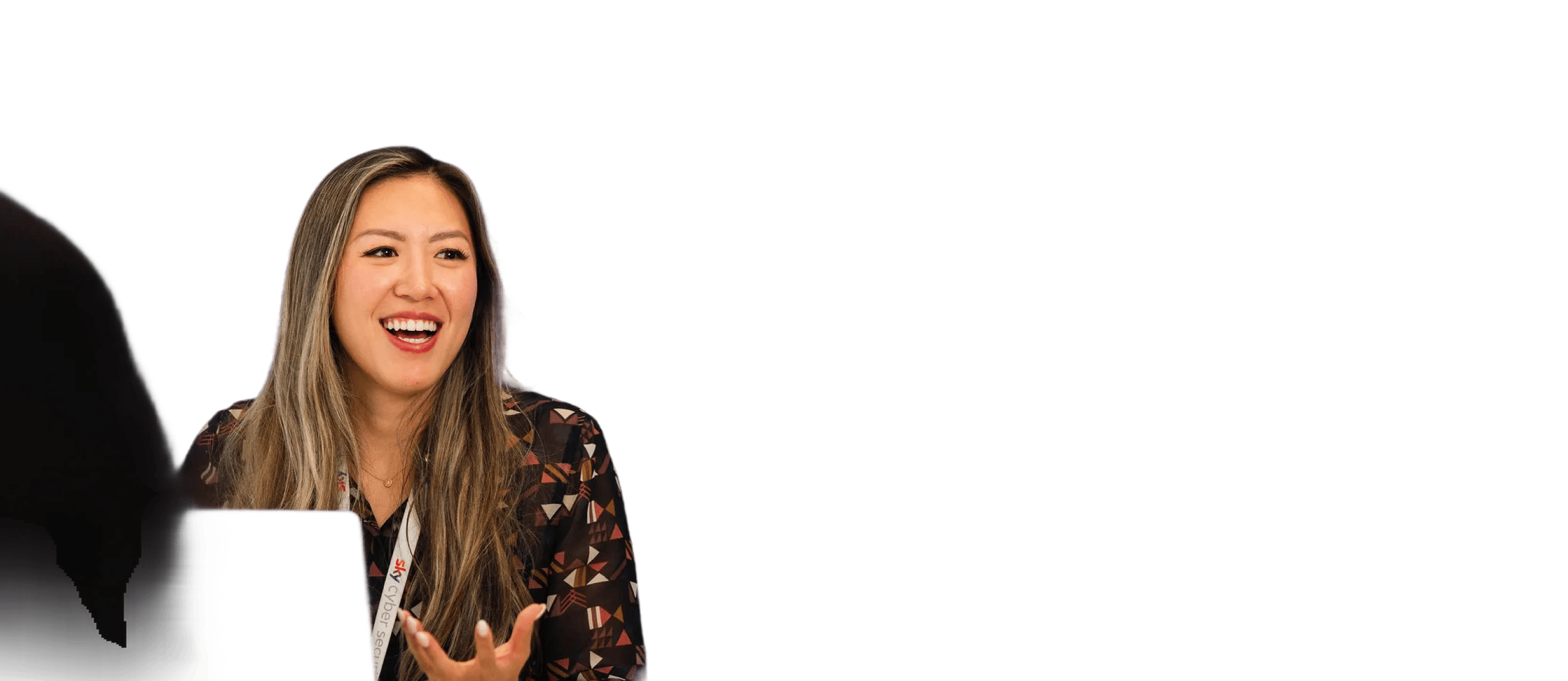 Woman in patterned shirt smiling and gesturing, isolated on a white background.