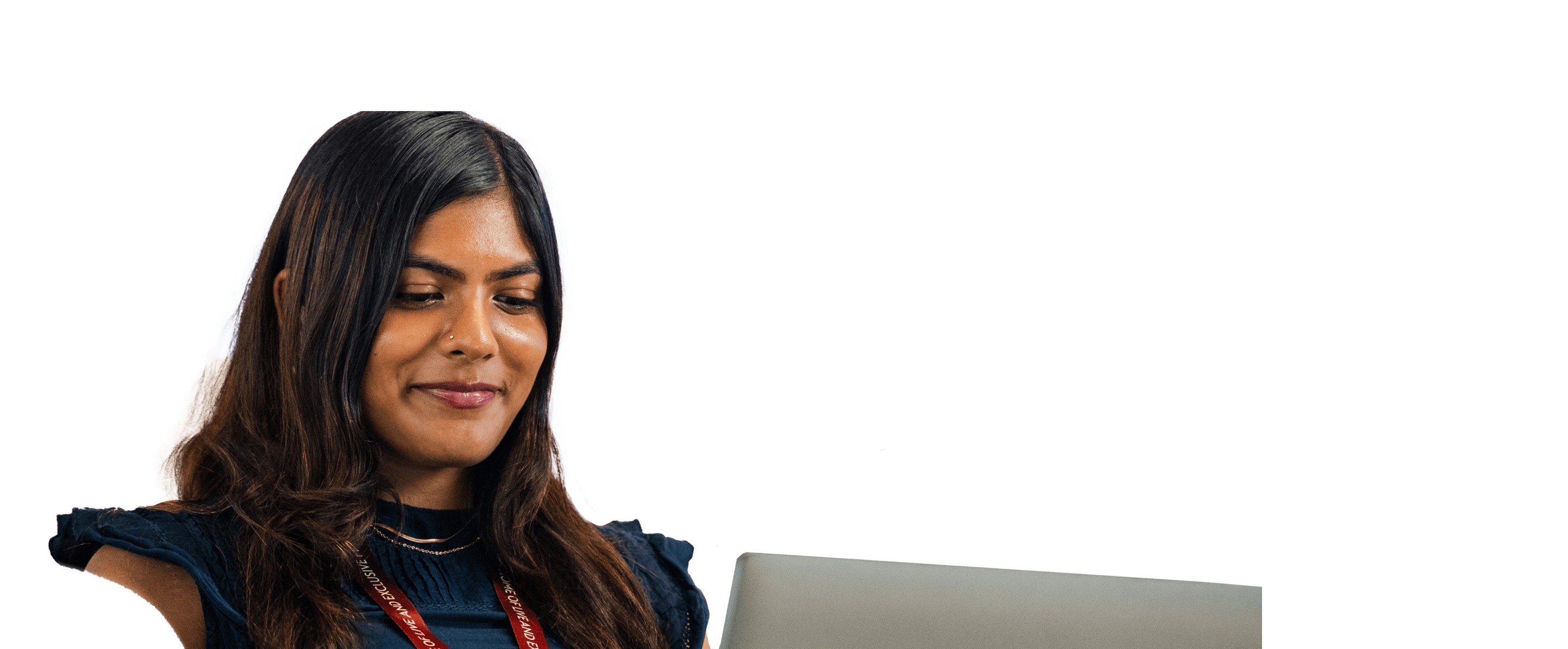 Woman wearing a Sky lanyard smiles while working on a laptop.