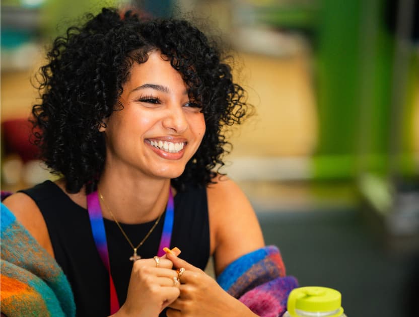 A woman with dark curly hair smiling