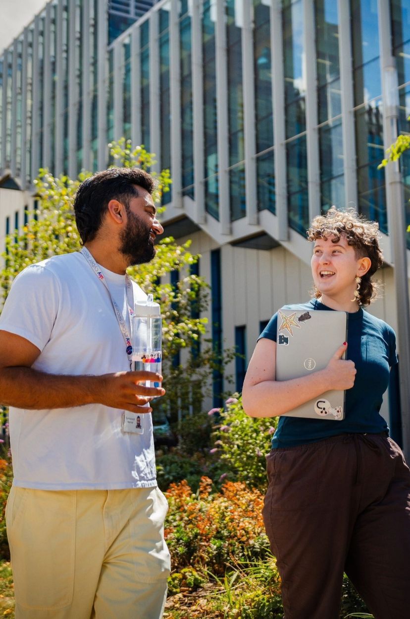 Two people walking outside in a garden