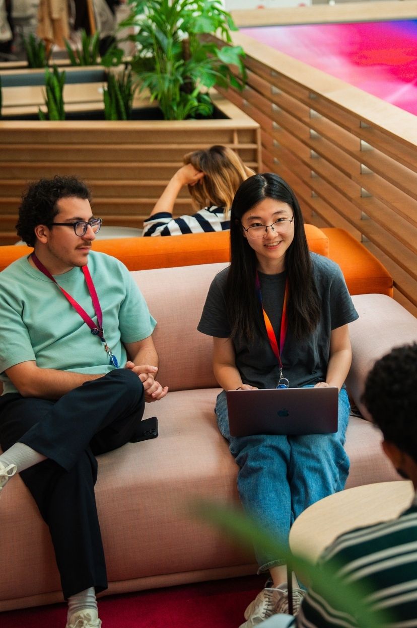 Three people sitting having a catch up on sofas
