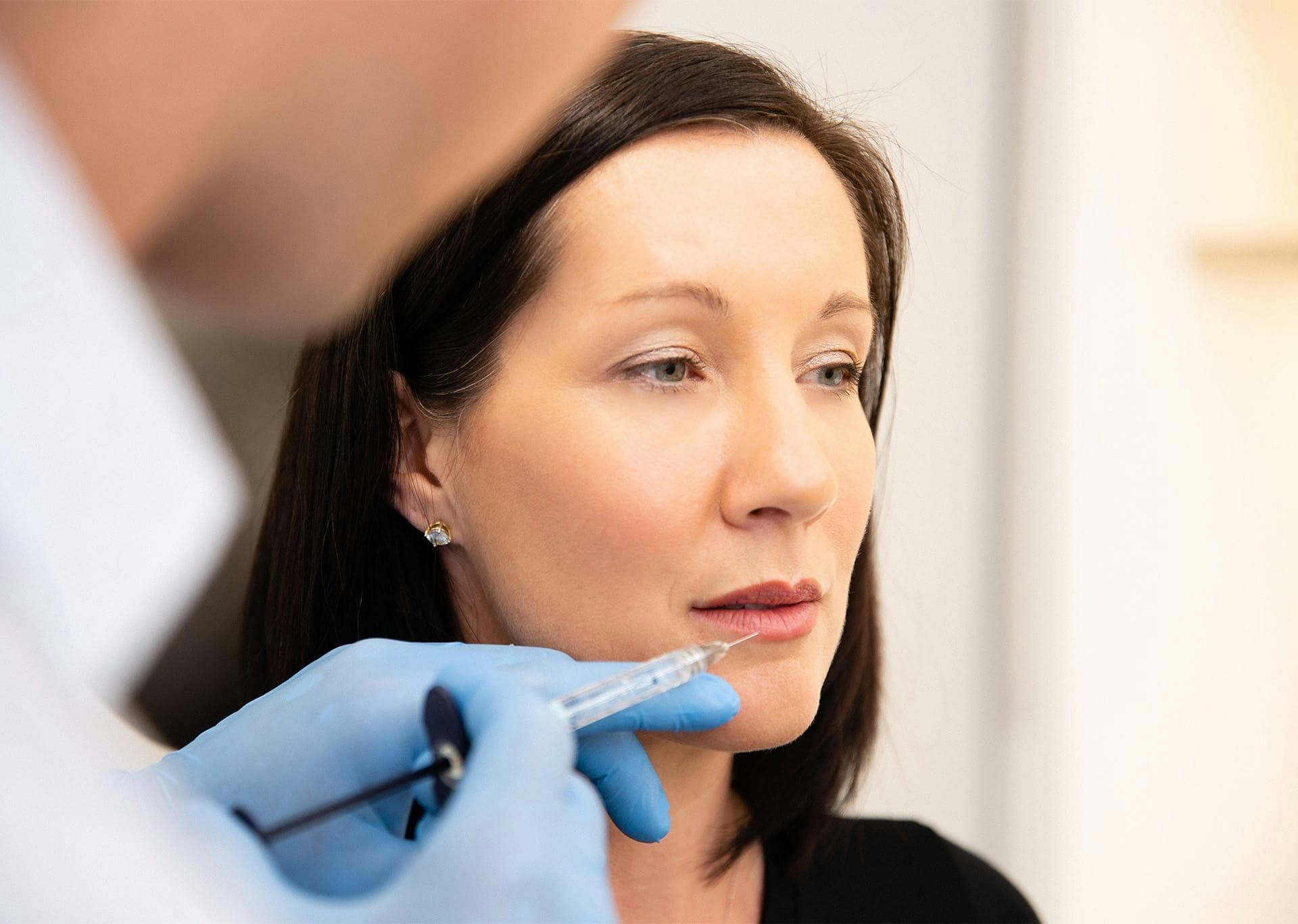 Dr. Brace applying lip injections to patient