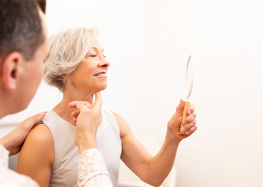 Dr. Brace examining patient's neck with mirror