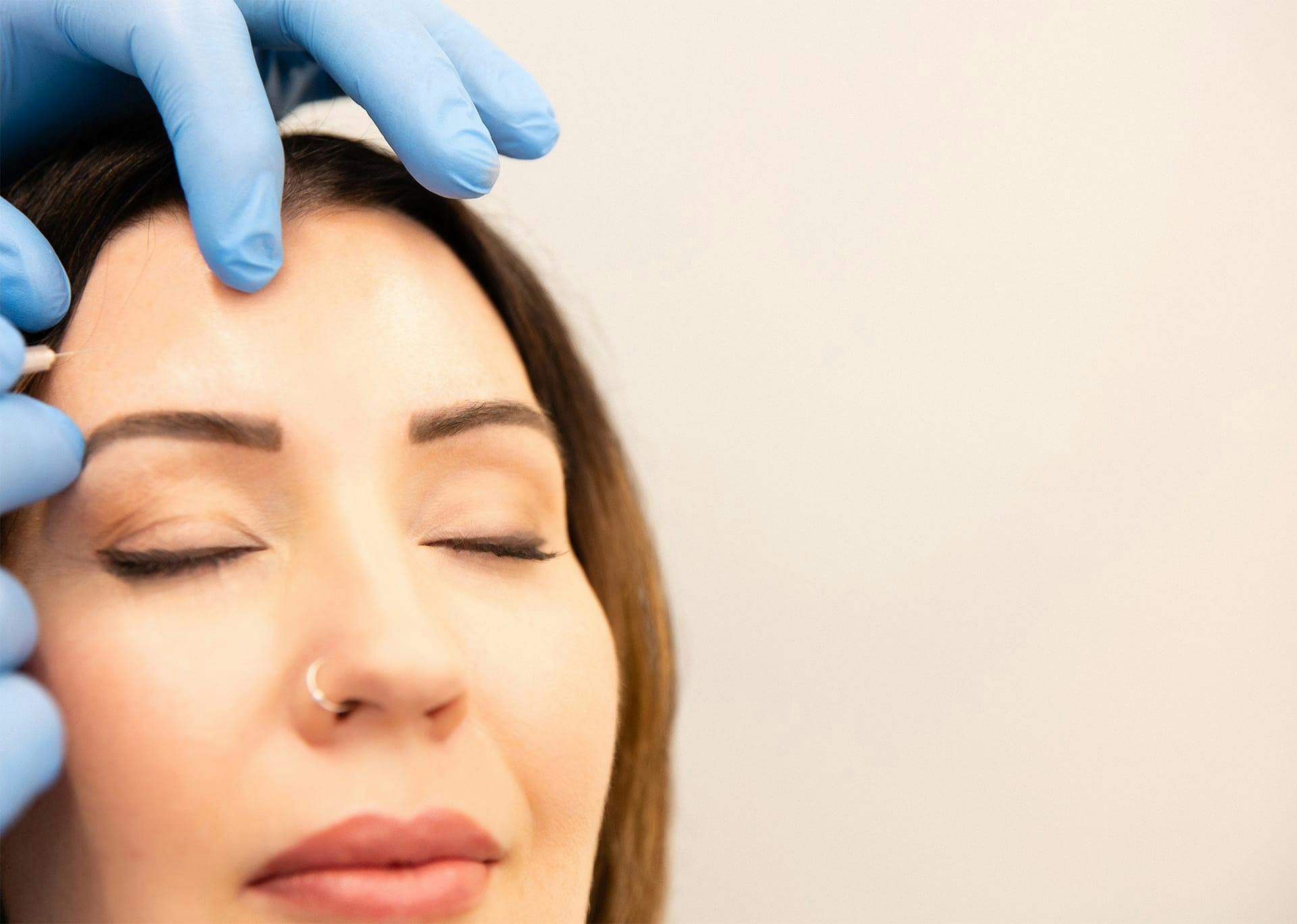 Dr. Brace performing injections to patient's forehead