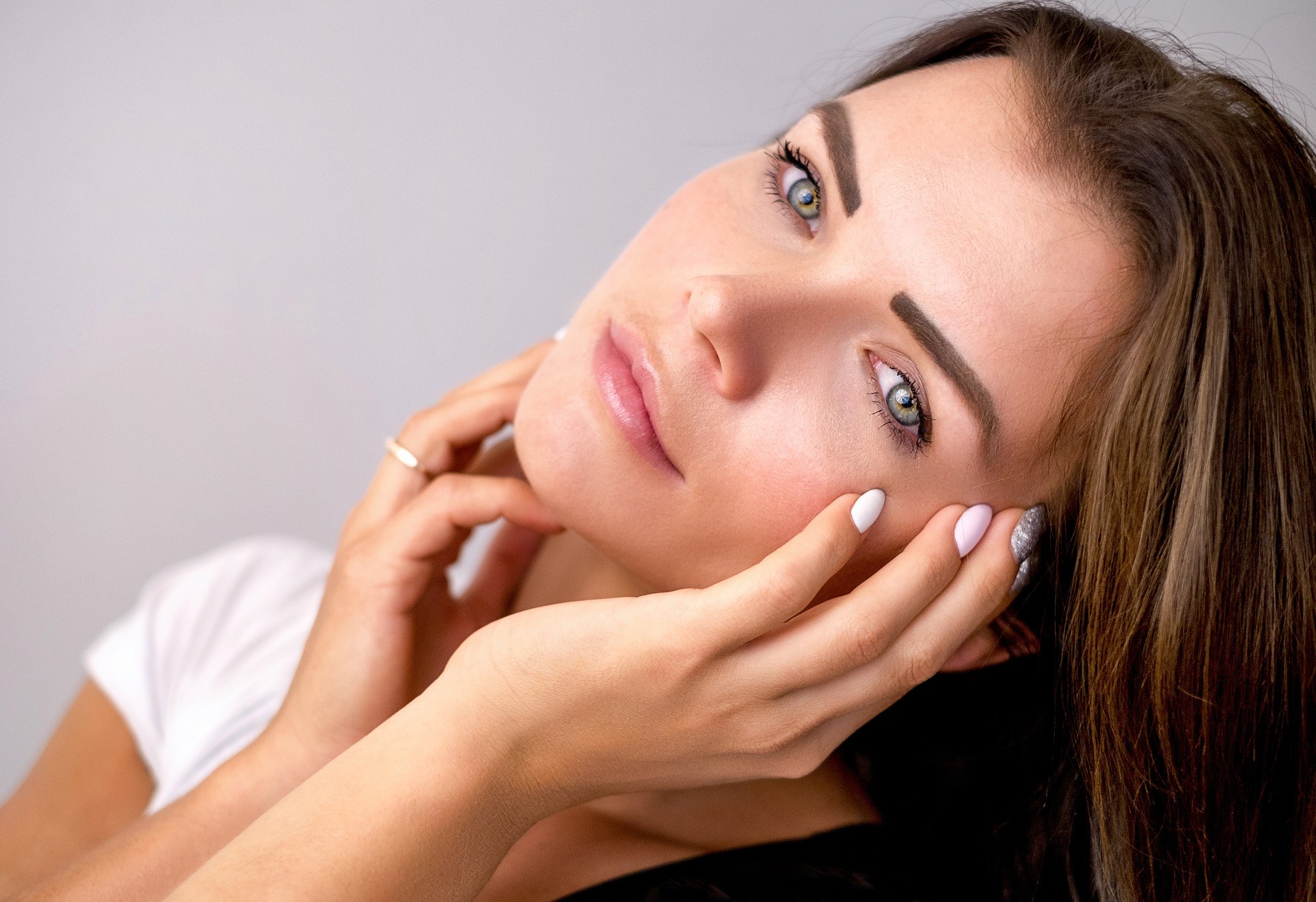 Woman tilting her head with hand on her face